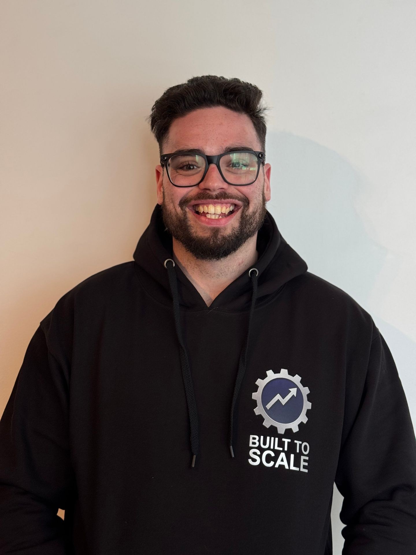 Adam “Puffy” Gould, Co-Founder and COO of PTSI, standing confidently in business-casual attire, known for building sales systems, marketing automations, and backend frameworks that help gyms scale predictably and sustainably.